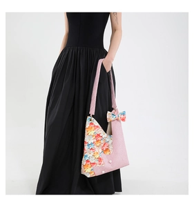 Detail of pink floral tote bag with 3D colorful flowers, pearls, and ribbon accessory