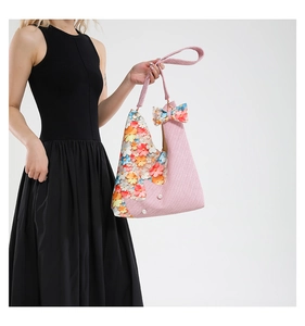 Close-up of pink herringbone weave tote with 3D floral accents and pearl details