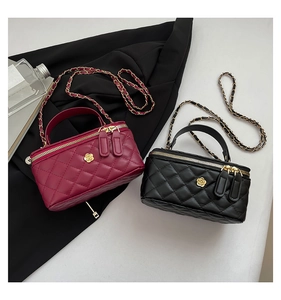 Close-up of quilted chain bags in black and wine red with gold camellia floral hardware