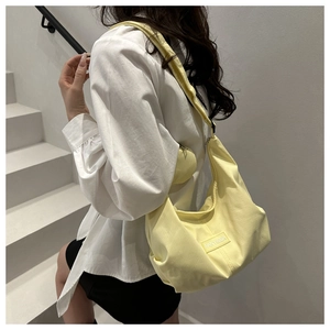 Close-up of yellow oxford tote bag featuring pleated texture and round coin purse detail