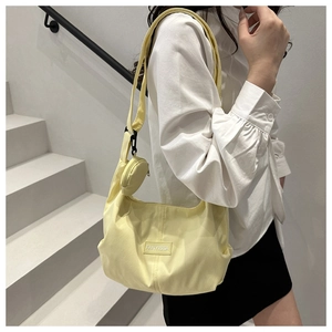 Detail of light yellow crescent shoulder bag with corduroy texture and mini coin purse