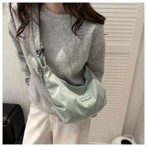 Dettaglio della borsa a mezzaluna verde chiaro in nylon con portamonete sulla tracolla