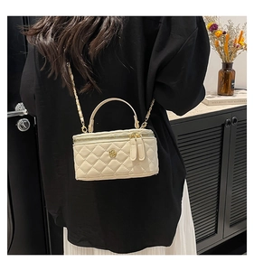 Quilted cream chain bag detail with gold flower charm and elegant metal leather strap