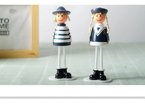Detail of handcrafted wooden navy dolls with blue stripes and long dangling legs