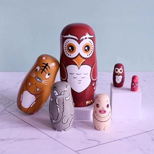 Hand-painted wooden animal nesting dolls set including owl and tiger on display stands