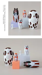 Detail of five-piece hand-painted wooden dog nesting dolls with a small bone accessory