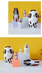 Detail of five-piece hand-painted wooden dog nesting dolls with a small bone accessory
