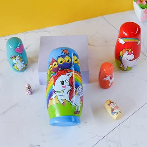 Handcrafted wooden nesting dolls featuring colorful unicorn and owl painted patterns