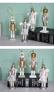 Close-up of wooden nutcracker and fairy Christmas tree ornaments in gold and white glitter