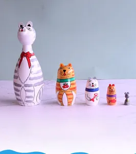 Detailed view of five handcrafted wooden nesting dolls with colorful cartoon cat patterns