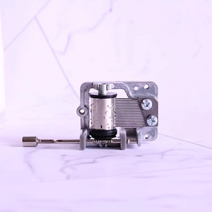 Manual hand-crank musical box mechanism in silver zinc alloy with a metal handle