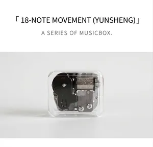 Detailed macro view of 18-note music box movement inside a clear plastic shell