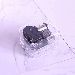 Detailed top view of a transparent acrylic music box showing internal silver metal movement