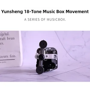 Detailed macro view of 18-note clockwork music box movement with gears and winding key