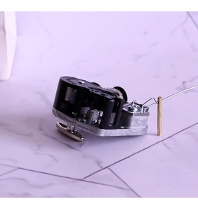 Close-up of mechanical music box movement with silver winding key and metal brake