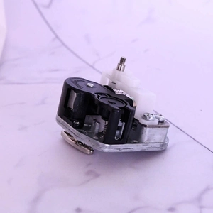 Macro view of mechanical music box movement with rotating clockwork and zinc alloy base