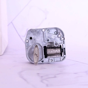 Precision mechanical music box movement with silver metal cylinder and wind-up key
