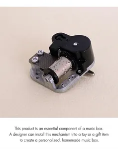Mechanical music box movement detail with silver metal base and black winding key part