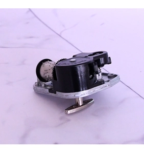 Macro detail of mechanical music box movement with silver metal cylinder and winding key
