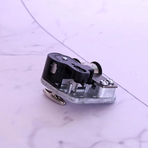 Detailed macro shot of an 18-note mechanical music box movement with butterfly winding key