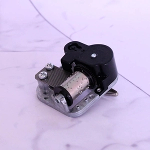 Mechanical music box movement with silver metal base and black plastic gears detail