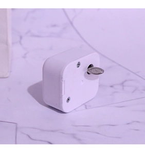 Detailed view of the winding key and white plastic shell of a mechanical music box movement