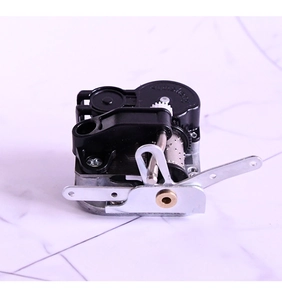 Mechanisches Spieluhrwerk mit schwarzem Gehäuse und rotierender Metallwalze