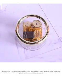 Macro view of golden hand-cranked music box movement with clear protective casing