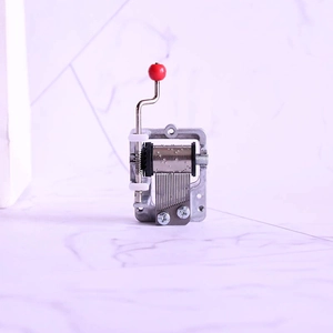 Detail of silver hand-crank music box mechanism with a vintage metal movement