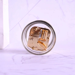 Mechanisches Spieluhrwerk in Gold mit transparentem rundem Gehäuse auf Marmorgrund