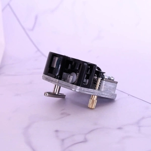 Close-up of DIY mechanical music box movement with silver base and golden winding key