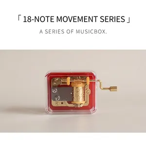Detail of hand-cranked 18-note music box with gold movement and clear plastic case