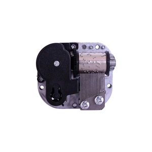 Mechanical music box movement with rotating base and metal comb mechanism on white background