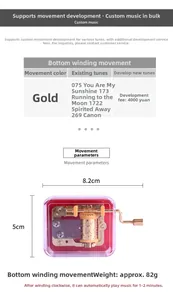 Detailed view of golden hand-crank music box movement with 8.2cm x 5cm dimensions