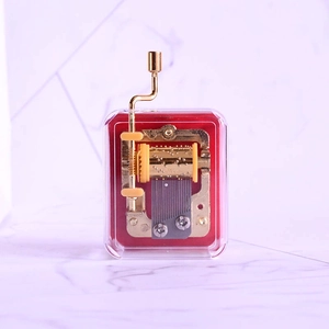 Detailed macro view of the gold-plated mechanical music box movement with clear shell