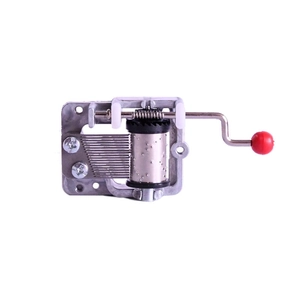 Mini DIY hand crank music box movement mechanism with red handle on white background