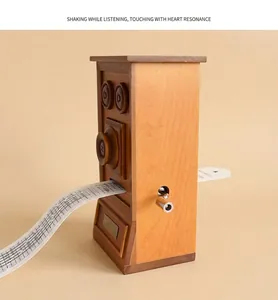 Détail de la boîte à musique en bois vintage avec fente pour bande et manivelle
