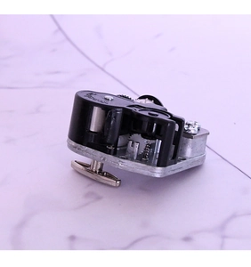 Macro view of mechanical wind-up music box movement with gear set and winding key