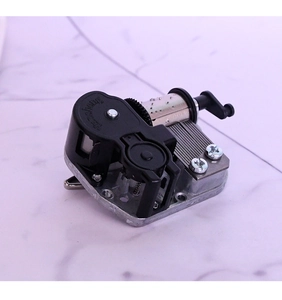 Mechanical music box movement with silver metal base and internal gear mechanism
