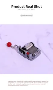 Close-up of DIY hand-cranked 18-note music box movement with metallic gears and red handle