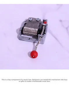 Mechanical 18-note hand-crank music box movement with a red ball handle and silver finish
