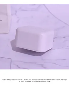 Macro detail of white plastic DIY music box movement component on marble background