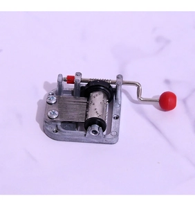 Detailed macro view of 18-note mechanical music box movement with crank and silver gears