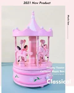 Macro detail of a pink carousel music box featuring white flower motifs on the base