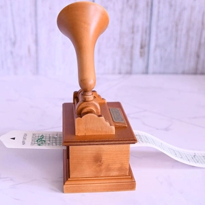 Vintage hand-cranked wooden music box with gramophone horn and Happy Birthday paper tape