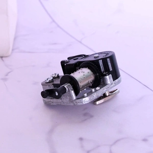 Detailed macro view of mechanical music box movement with metal drum and black gears