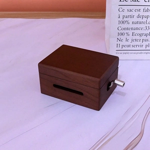 Détail d'une boîte à musique mécanique en bois avec manivelle et grain de noyer foncé