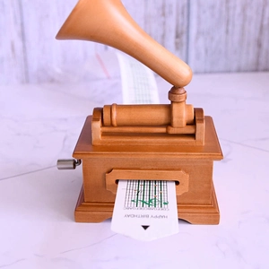 Detail of vintage wooden gramophone music box with Happy Birthday paper strip and hand crank