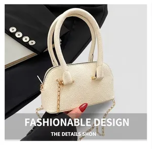 Detail of cream shell bag with lychee pattern leather and elegant gold chain strap