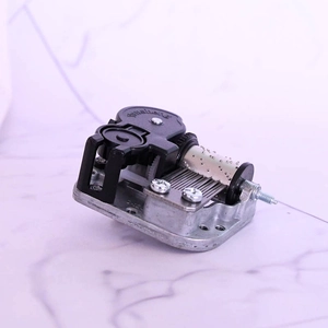 Macro view of 18-note Sankyo mechanical wind-up music box movement with silver metal base